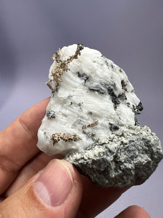 a hand holding a piece of rock that looks like a cluster of rocks