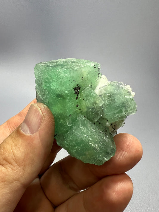 a person holding a piece of green rock