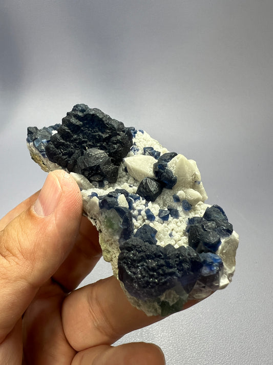 a hand holding a piece of blue and white rock